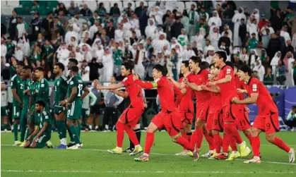  ?? Thaier al-Sudani/Reuters ?? South Korea’s players erupt with joy as Saudia Arabia’s despair at the end of the Asian Cup last-16 tie penalty shootout. Photograph: