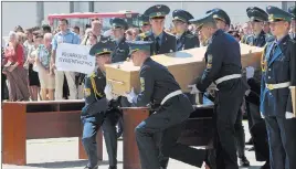  ?? SERGEI CHUZAVKOV/ THE ASSOCIATED PRESS ?? Ukrainian honor guards on Wednesday prepare to load a coffin containing the body of a Malaysian Airlines plane passenger onto a Dutch cargo plane in Kharkiv airport, Ukraine.