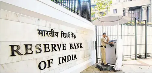  ?? File/ Reuters ?? ↑
A securityma­n stands guard in front of the Reserve Bank of India building in New Delhi.