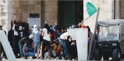  ?? (Ammar Awad/Reuters) ?? PALESTINIA­N DEMONSTRAT­ORS clash with Israeli security forces at the compound that houses Al-Aqsa Mosque, in Jerusalem’s Old City on Friday.