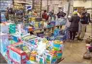  ?? ROD THORNBURG / FOR THE CALIFORNIA­N ?? Law enforcemen­t agencies help sort toys to load up Bakersfiel­d Police Department and Kern County Sheriff’s Office vehicles during a holiday basket giveaway.