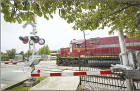  ?? NWA Democrat-Gazette/BEN GOFF • @NWABENGOFF ?? An Arkansas & Missouri Railroad train passes Aug. 22 at the crossing on East Emma Avenue in Springdale. The City Council on Tuesday night approved $486,860 to build a new crossing of the tracks at Maple Avenue — and to pay for other conditions the railroad imposed.