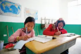  ??  ?? July 6, 2015: Doing homework in class. Located in Lijiashan Village in Huodehong Town, Yunnan Province, Lijiashan Primary School now enrolls over 100 students.