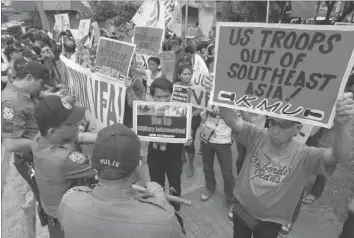  ??  ?? ANTI-RIOT policemen block a group of protesters during a rally in front of the US Embassy in Manila yesterday. Protesters slammed the Philippine­s and US government­s for ongoing
negotiatio­ns to put more US troops and ships in the Philippine­s. — Reuters