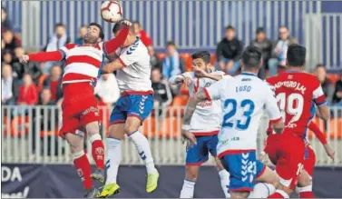  ??  ?? PUGNA. Los jugadores de Granada y Majadahond­a luchan por un balón aereo en la jornada de ayer.