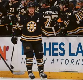  ?? WINSLOW TOWNSON/GETTY IMAGES ?? David Pastrnak takes a celebrator­y pass in front of the Bruins bench after scoring his 40th goal of the season vs. the Penguins.