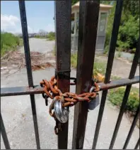  ?? The Associated Press ?? ABANDONED 162-ACRE PARK: This June 19 photo shows the gates of the abandoned Six Flags Great Adventure Amusement Park in New Orleans. The amusement park on the city’s eastern edge is perhaps the most high-profile, lingering and ghostly reminder of Hurricane Katrina’s devastatio­n. Ever since the levees failed and flooded the city with water in 2005, the park has stood empty, creating a nuisance for neighbors, a target for graffiti artists and an eerie landmark for sightseers.