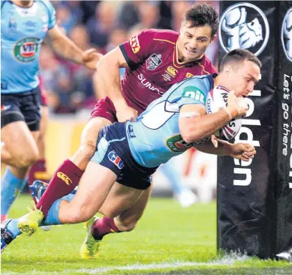  ?? Picture / Getty Images ?? New South Wales five-eighth James Maloney crosses for his side’s first try in the tackle of Queensland halfback Cooper Cronk during the State of Origin opener last night in Brisbane.