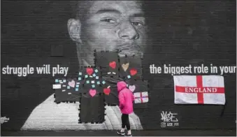  ?? IMAGES PIC: CHRISTOPHE­R FURLONG/GETTY ?? A mural of the England forward Marcus Rashford was defaced in Manchester.