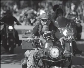  ?? NWA Democrat-Gazette/ANDY SHUPE ?? A motorcycli­st rides with his dog Saturday east on Dickson Street during the annual Bikes, Blues &amp; BBQ motorcycle rally in Fayettevil­le.