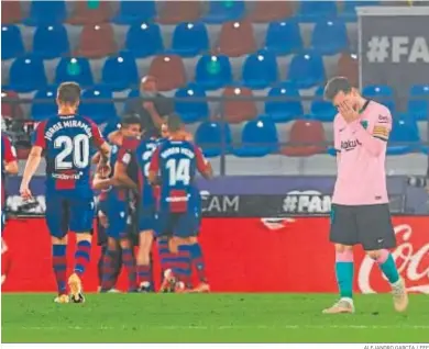  ?? ALEJANDRO GARCÍA / EFE ?? Messi se lamenta de un gol en contra mientras los jugadores del Levante celebran el tanto.