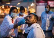  ?? (AFP) ?? A health worker collects a nasal swab sample from a Hindu devotee to test for the COVID-19 virus during the ongoing Kumbh Mela festival in the northern Indian city of Haridwar on Monday