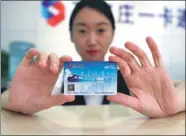  ?? ZHANG XIUKE / XINHUA TIBET ?? A new transit card, which is designed for use on all bus and subway systems in Beijing, Tianjin and all 11 cities in Hebei, is issued in Shijiazhua­ng, Hebei province, on Monday.