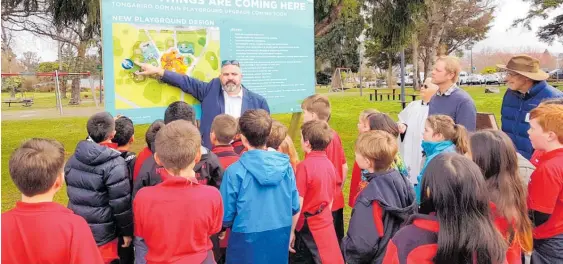  ??  ?? Taupo¯ District Council playground project sponsor Dylan Tahau outlines the new playground’s features to Taupo¯ Primary School room 18 students. The Rev Peace Mitchell, who performed the blessing for the new project, is at right.