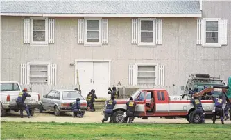  ?? Associated Press file photo ?? Federal Alcohol Tobacco and Firearms agents approach the Branch Davidian compound near Waco in 1993, setting off a 51-day standoff that ended with the fiery deaths of almost 80 people.