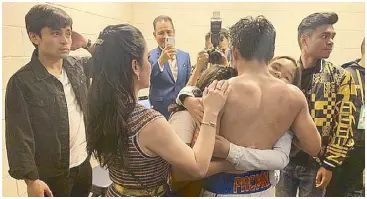  ??  ?? Pacquiao is embraced by his daughters Princess and Queenie while wife Jinkee and sons Jimuel and Michael look on in the locker room after the fight.