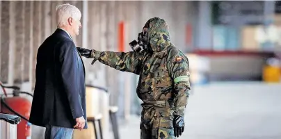  ?? [ Imago ] ?? Ein spanischer Soldat stoppt einen Passanten, während seine Kameraden den Bahnhof der Stadt Irun desinfizie­ren.