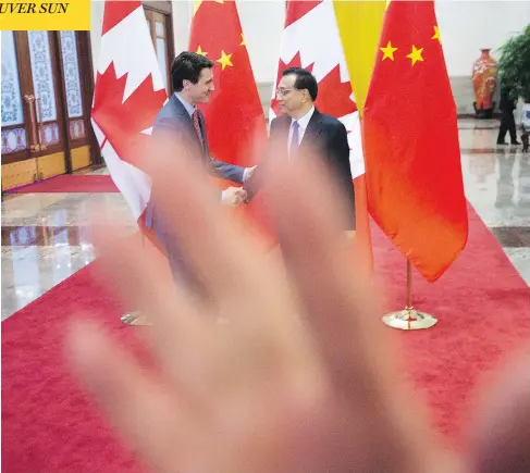  ?? SEAN KILPATRICK / THE CANADIAN PRESS ?? A security guard attempts to block a photograph­er taking a photo of Prime Minister Justin Trudeau being greeted by Chinese Premier Li Keqiang at the Great Hall of the People in Beijing on Monday. The incident foreshadow­ed a less-than-warm reception to...