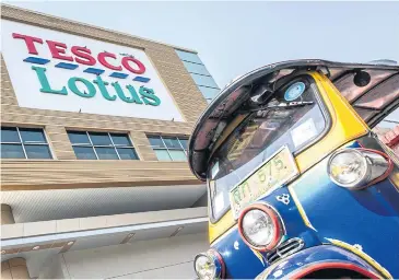  ?? AFP ?? A tuk-tuk waits for customers outside a Tesco-Lotus supermarke­t in Bangkok. Supermarke­t chain Tesco Plc is looking to sell its businesses in Thailand and Malaysia.