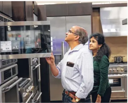  ?? Mark Mulligan / Houston Chronicle ?? Gana and Aruna Mahendrava­da shop for kitchen appliances at the Best Buy on Richmond near Loop 610. Their home in Bellaire was flooded with 10 inches of water last month.