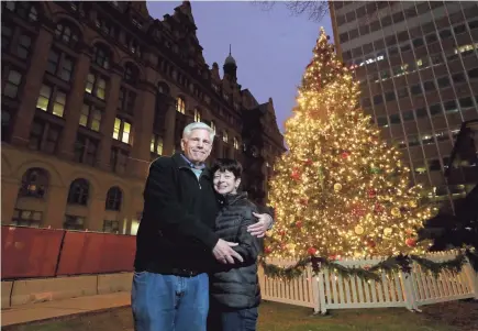  ?? MIKE DE SISTI/MILWAUKEE JOURNAL SENTINEL ?? Edward and Kathy Gill stand in front of the Milwaukee Christmas tree across from City Hall on Saturday. The tree has special meaning for the Gills, who donated the 35-foot spruce from their yard on the city’s northwest side. They planted two trees — a Colorado blue spruce and a red maple — in honor of their sons, Eddie and Andy, who were killed in a car crash in 1998 two blocks from their home. The maple still stands in their yard and now the spruce is on display outside City Hall, decked for the holidays.