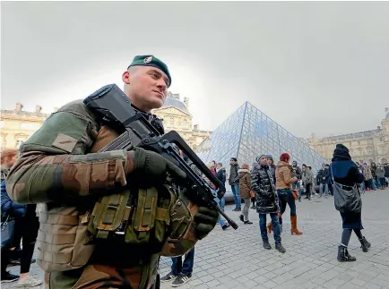  ?? REUTERS ?? French soldiers patrol the Louvre Museum in Paris yesterday as emergency security measures are put in place ahead of New Year’s Eve celebratio­ns in and around the French capital.