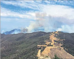  ?? AP PHOTO ?? This photo provided by KEYT-TV shows smoke looming above Broadcast Peak behind a fire break along a ridge line east of Cachuma Lake in Santa Barbara County, Calif., Sunday. Wildfires barreled across the baking landscape of the western U.S. and Canada,...