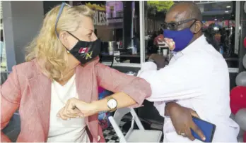  ??  ?? Canadian High Commission­er to Jamaica Laurie Peters gives Local Government Minister Desmond Mckenzie and Member of Parliament for Kingston Western an elbo bump during yesterday’s official opening of the new Island Grill restaurant in downtown Kingston.