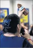  ?? Genaro Molina Los Angeles Times ?? AT THE forum, Maria Villarreal of Compton holds up a bottle of brown water that she said came from the tap in her home.