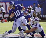  ?? BILL KOSTROUN — THE ASSOCIATED PRESS ?? New York Giants quarterbac­k Eli Manning (10) fumbles the ball as he is tackled behind the line of scrimmage during the second half of an NFL football game against the Buffalo Bills, Sunday in East Rutherford, N.J.