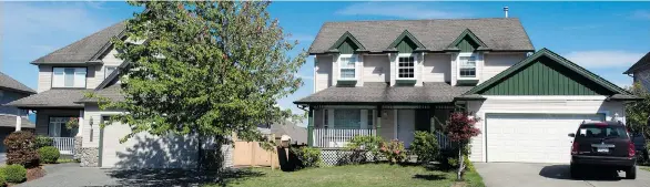  ?? PHOTO: JENELLE SCHNEIDER/PNG ?? Ping Shun Ao was killed in a drive-by shooting as he stood outside his house, left, in Abbotsford earlier this week. The house on the right was the intended target.