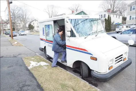  ?? Hearst Connecticu­t Media file photo ?? A U.S. postal worker enters her truck while delivering mail on Henry Street in the Byram section of Greenwich in 2013.