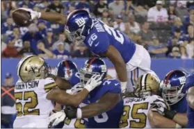  ?? BILL KOSTROUN - THE ASSOCIATED PRESS ?? New York Giants’ Saquon Barkley jumps over defenders for a touchdown during the second half of an NFL football game against the New Orleans Saints, Sunday, Sept. 30, 2018, in East Rutherford, N.J.