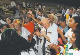  ?? Kathryn Scott, Special to The Denver Post ?? As music blares from large speakers, U.S. Rep. Mike Coffman joins a crowd as they dance in celebratio­n for the Ethiopian New Year at Aurora Public Schools Stadium in Aurora on Sept. 16.