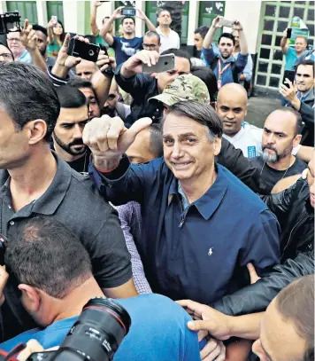  ??  ?? Jair Bolsonaro, the far-right Brazilian presidenti­al candidate, gives the thumbs-up after casting his vote in Rio de Janeiro