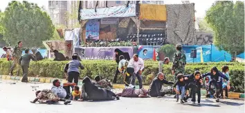  ?? AFP ?? Residents take cover or flee from an attack on a military parade that was marking the anniversar­y of Iran’s 1980-1988 war with Saddam’s Iraq in Ahvaz city.