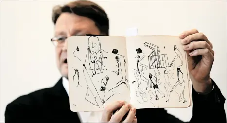  ?? MENAHEM KAHANA/GETTY-AFP ?? Stefan Litt, an archivist at Israel’s National Library, last week displays some drawings by novelist Franz Kafka.