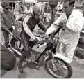  ??  ?? ABOVE Jack Forrest steadies the BMW R75 for Bob Pressley while Don Wilson refuels in the 1970 Castrol 1000 (Six Hour) race.