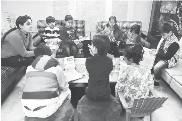  ??  ?? Ruchi Taneja (left) teaches a group of Indian children studying with an app created by Planet Sparks that uses ‘gamified’ teaching methods at a tuition centre in New Delhi.