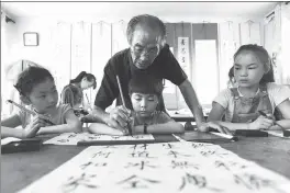  ??  ?? From left: Visitors from Malaysia and Ecuador show their interest in Chinese calligraph­y in Anyang, Henan province; Ge Shulan, 83, teaches children calligraph­y during a course in Jimo, Shandong province. Ge has volunteere­d to give calligraph­y lectures at weekends and during vacations for 10 years; a Russian boy gives his inkpad to a Chinese boy at a calligraph­y contest in Dalian, Liaoning province, in March.