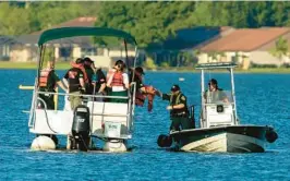  ?? ERNST PETERS/THE LEDGER ?? Polk County Sheriff Underwater Search & Recovery Team search the area around a partially submerged aircraft that crashed into Lake Hartridge after colliding with another aircraft on Tuesday in Winter Haven.