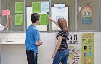  ??  ?? Dos menores observan la lista de los selecciona­dos en el Bachillere­s Plantel 5