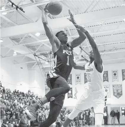  ?? KARL MERTON FERRON/BALTIMORE SUN ?? Poly senior Demetrius Mims Jr. roars in for a slam dunk after a breakaway steal while guarded by Dunbar’s Da’Shawn Phillip. Mims scored six points to help the Engineers (14-5) defeat the host Poets, 65-61, handing Dunbar (18-1) its first loss of the...