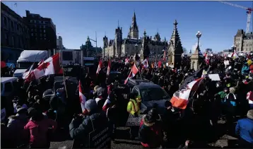  ?? ADRIAN WYLD — THE CANADIAN PRESS ?? Protestors mingle around vehicles parked in front of West Block and the Parliament buildings in Ottawa on Saturday as they protest measures to curb the spread of COVID-19.