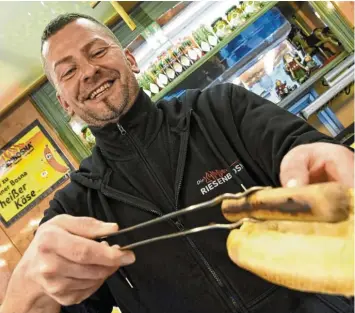  ?? Fotos: Silvio Wyszengrad ?? Ronald Plötz serviert auf dem Fuggerplat­z vegetarisc­he Wurst.