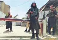  ?? AP ?? Taliban fighters stand at a checkpoint near the U.S. embassy in Kabul that was previously guarded by American troops.