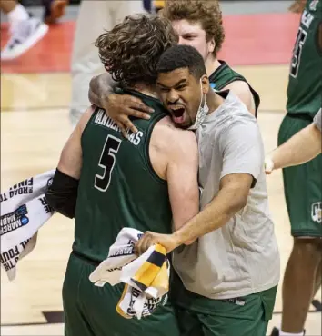  ?? Associated Press ?? Jsason Vander Plas, left, receives a hug from a teammate after Ohio upset Virginia Saturday night in the first round of the NCAA tournament in Bloomingto­n, Ind. Vander Plas scored a team-high 17 points for the Bobcats.