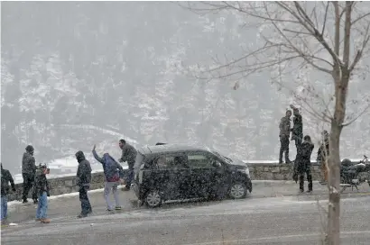  ?? —AFP file ?? Pakistani tourists enjoy the snowfall in Murree, some 65km from Islamabad, in January, 2017.