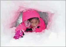  ?? SEAN D. ELLIOT/THE DAY ?? Melia Guilbert-Ho, 7, crawls through a snow tunnel dug with her mother, Tifanee Guilbert, and brother Keanu Guilbert-Ho, 5, outside their Cleveland Street home in New London.