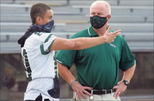  ?? Ned Gerard / Hearst Connecticu­t Media ?? Norwalk quarterbac­k Tommy Brown speaks with athletic director Doug Marchetti during a practice in 2020.